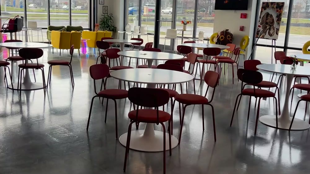 The main hall with round tables and chairs, ready for guests